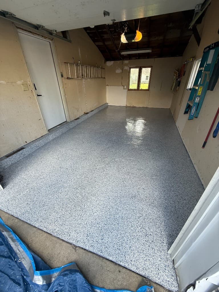 After coating: grey white and black flake garage floor with high-gloss finish.