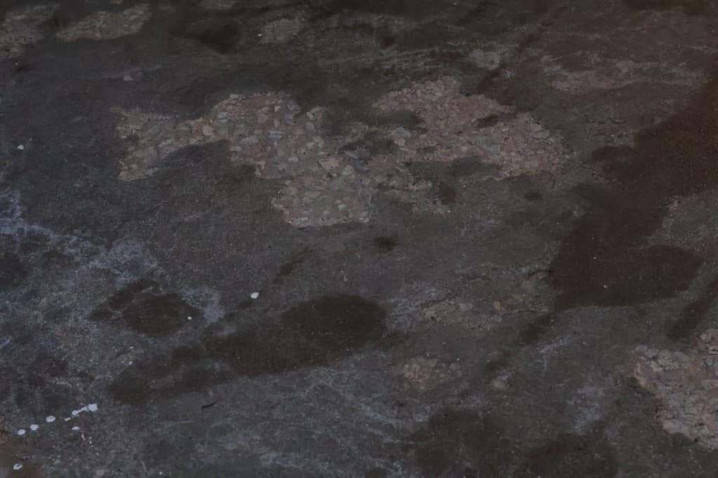 Before coating: damaged concrete with patching marks.