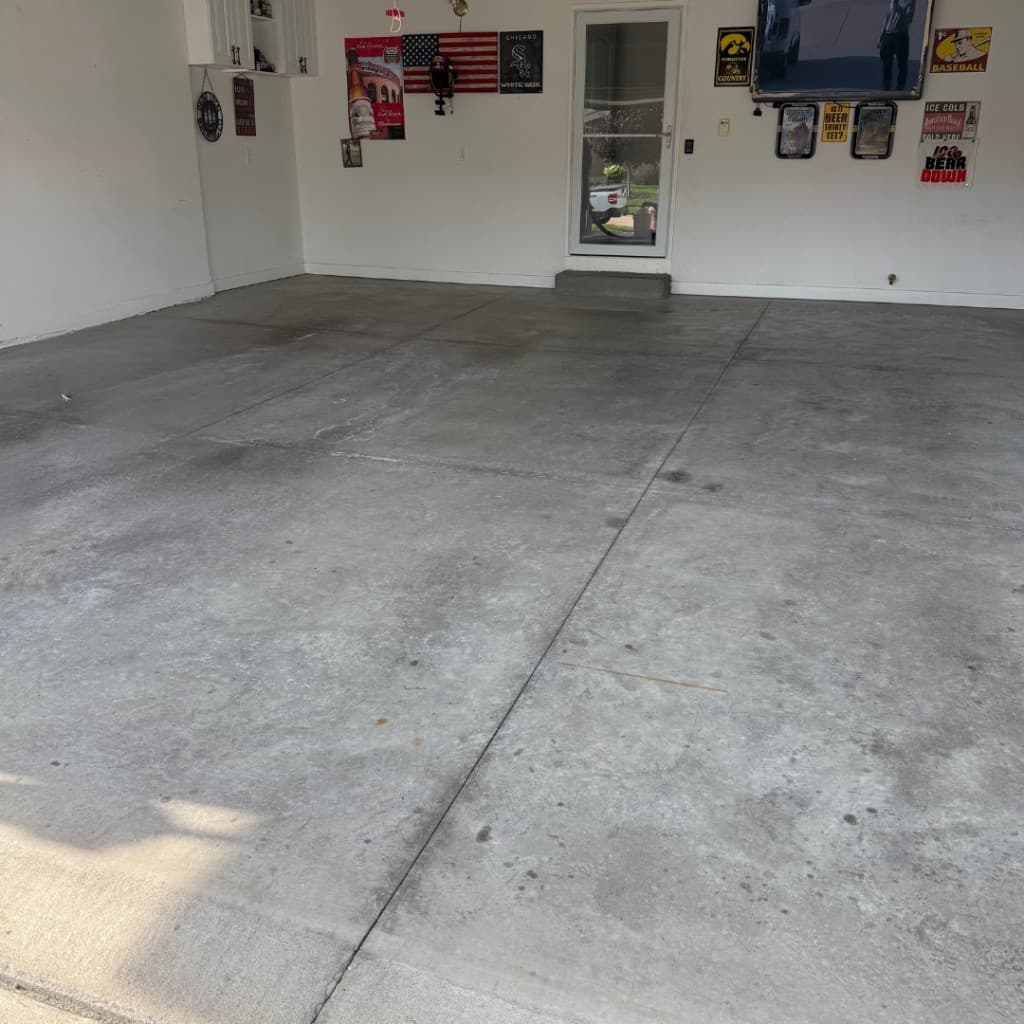 Stained garage floor before coating with plain walls.