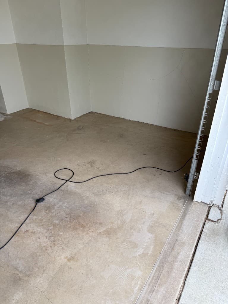 Worn stained concrete garage floor before coating.